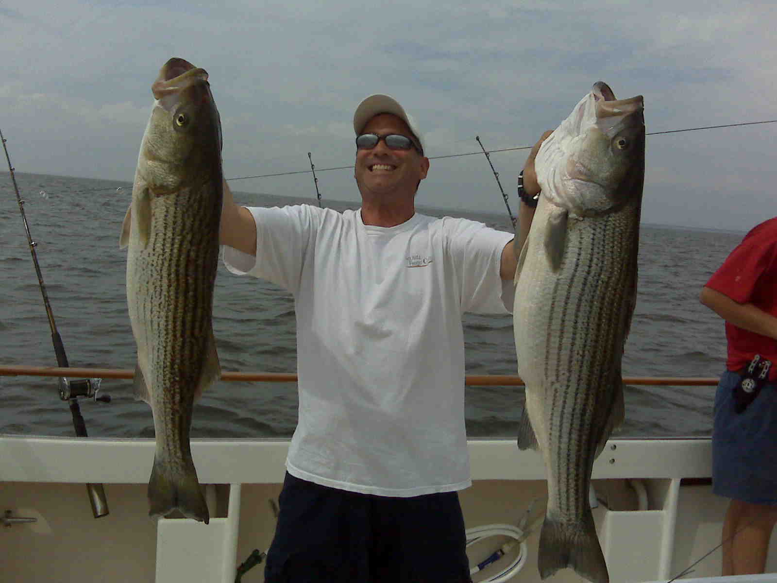 Angler with largemouth bass on lake