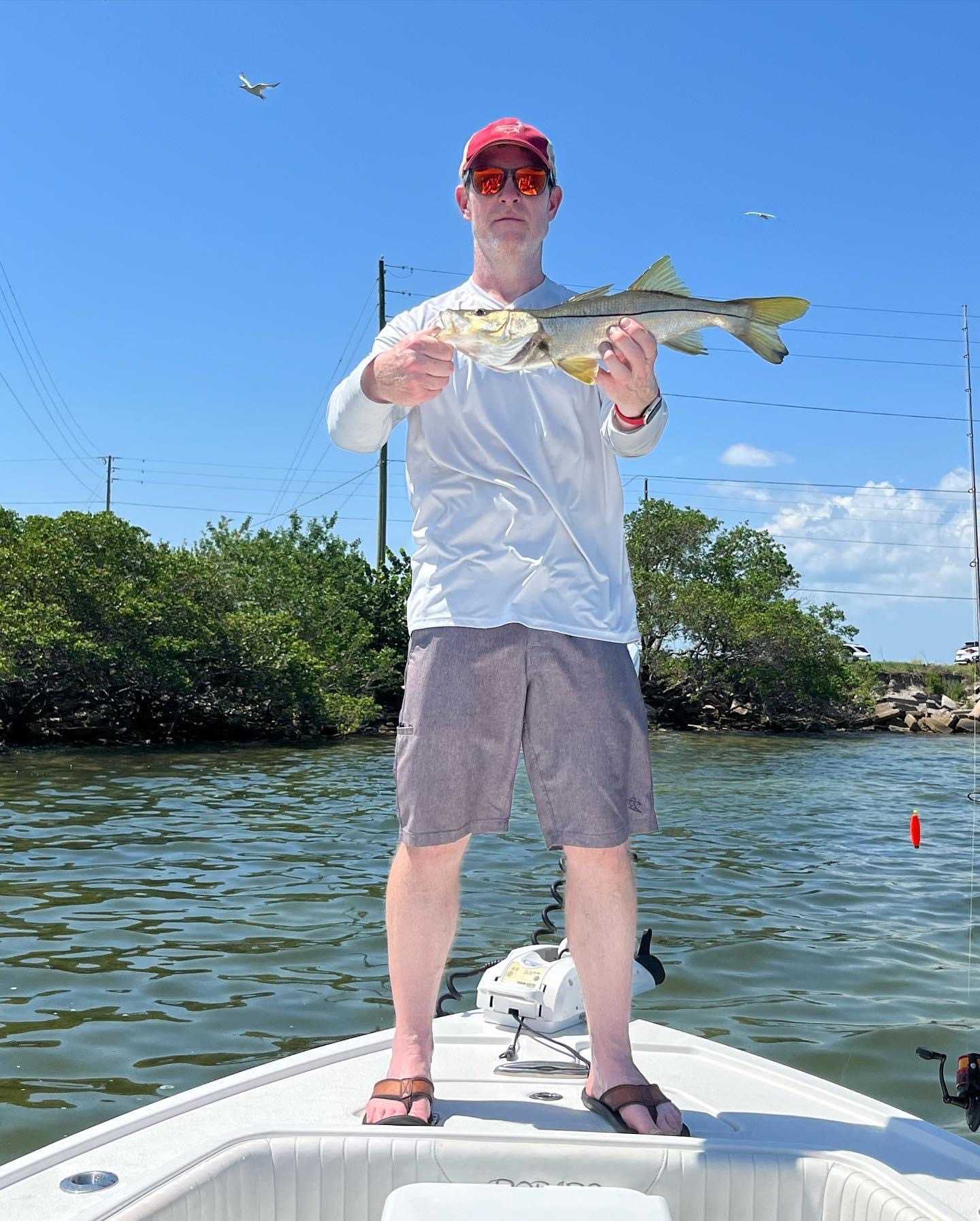 Florida angler with snook caught from boat near mangrove shoreline
