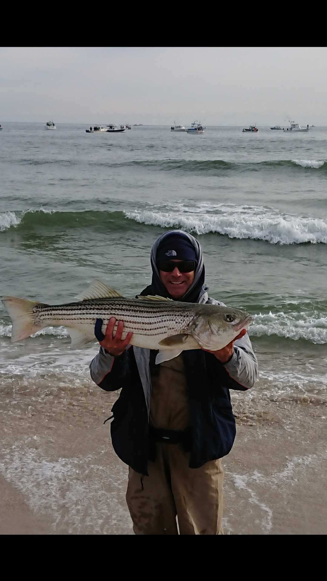 Angler with trophy striped bass at home