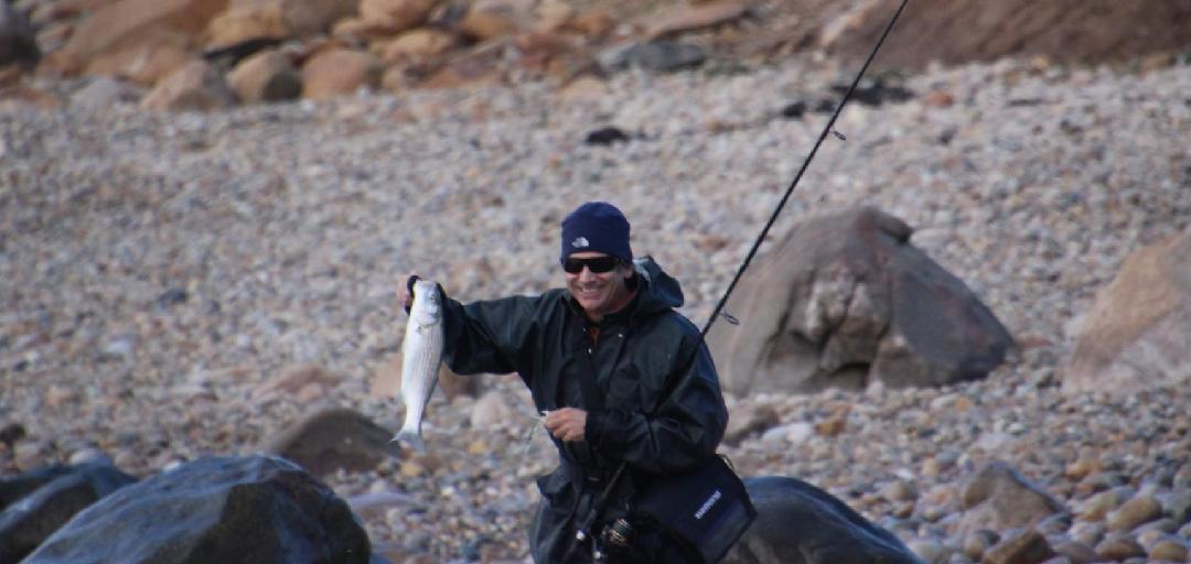 Charter angler with two striped bass Chesapeake Bay