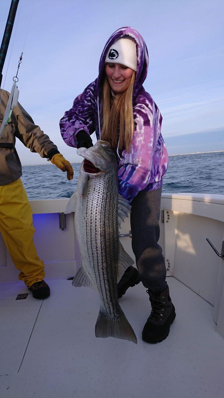 Angler with two striped bass on Chesapeake Bay charter